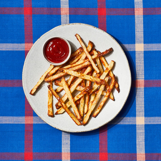 french fries on a grey plate with ketchup