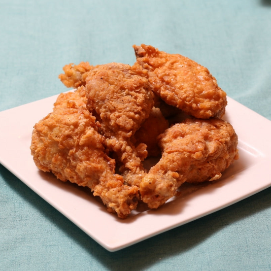 Pile of fried chicken on a square white plate