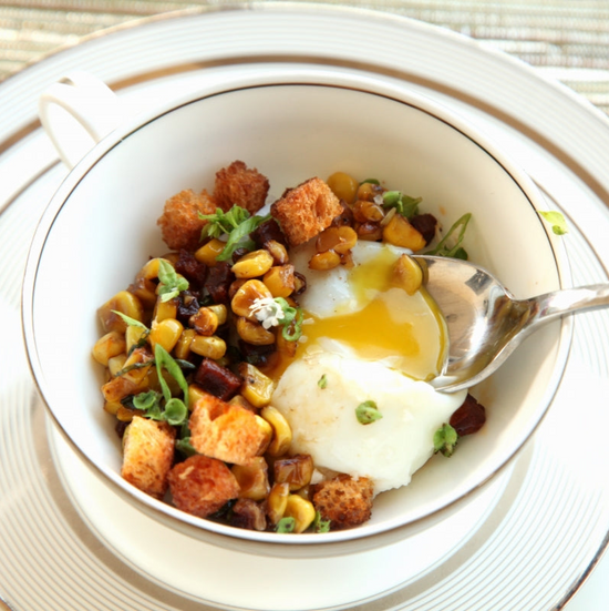 Poached egg with a runny yolk on a cup of vegetable hash