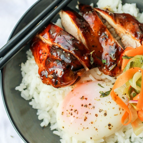 Teriyaki chicken on a bed of rice with an egg and vegetables