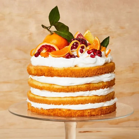 Genoise sponge layer cake with whipped cream and citrus fruit