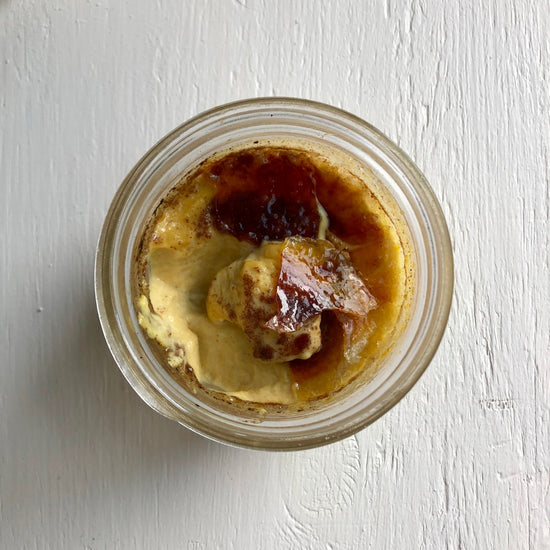cracked pumpkin creme brulee in clear jar on white surface