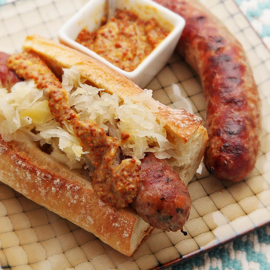 sous vide sausage in a baguette topped with sauerkraut and mustard