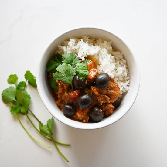 venison pastele stew in a white bowl with rice